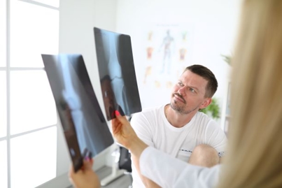 Man at Doctor's Appointment Viewing X Rays from Work Injury